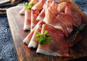 Italian prosciutto crudo or jamon with parsley. Raw ham.